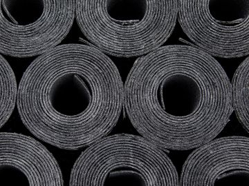 Rollos de material negro enrollados en forma circular.