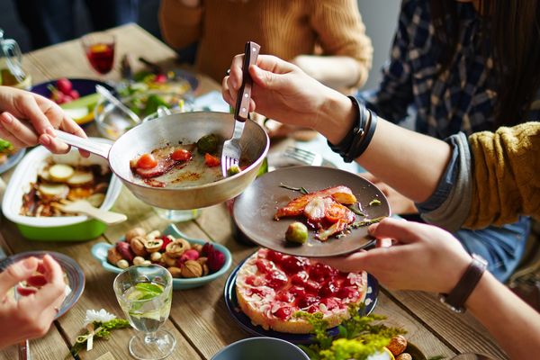 People sharing a meal with various dishes on the table.