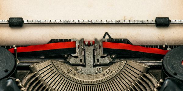 Close-up of vintage typewriter with blank paper.