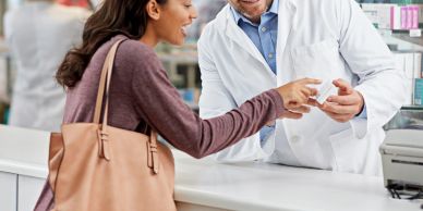 A woman consulting with a pharmacist at the counter.