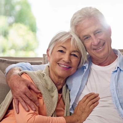 Happy elderly couple embracing and smiling.