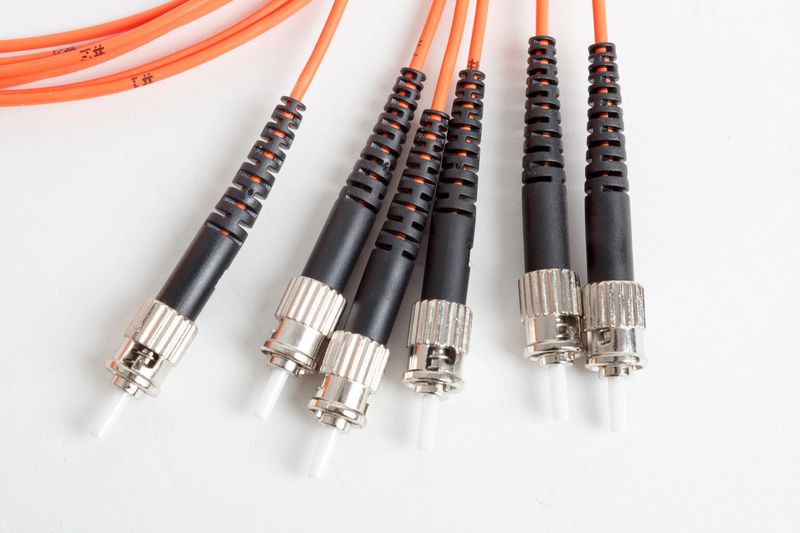 group of fiber optic ST connectors on orange patchcord