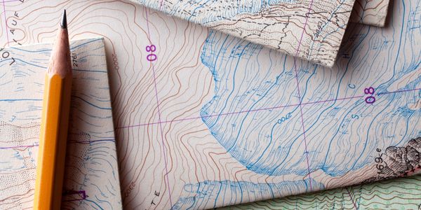 Geological contour map and pencil representing project cargo and commercial sample shipping bluprint