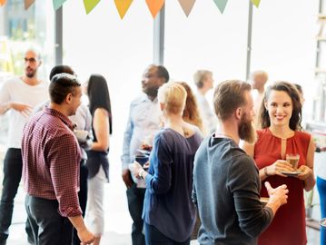 People engaging in conversation at a social gathering indoors.
