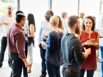 People engaging in conversation at a social gathering indoors.