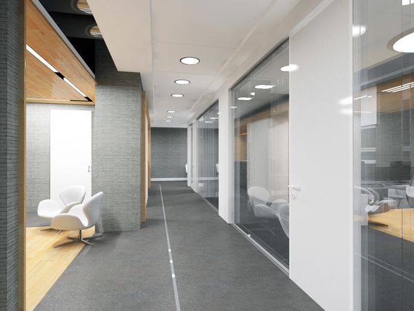 Modern office hallway with glass walls and white chairs in a waiting area.