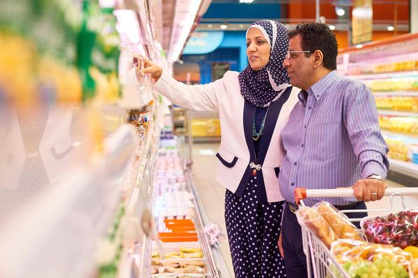 Couple shopping in a supermarket aisle.