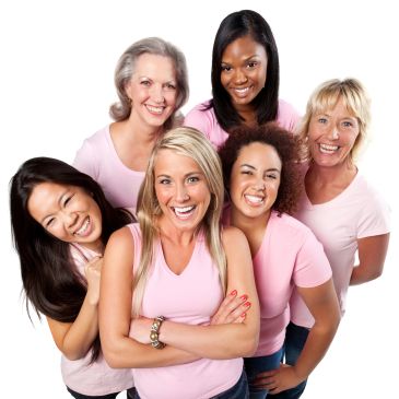 A diverse group of six women smiling, all wearing pink tops against a white background.