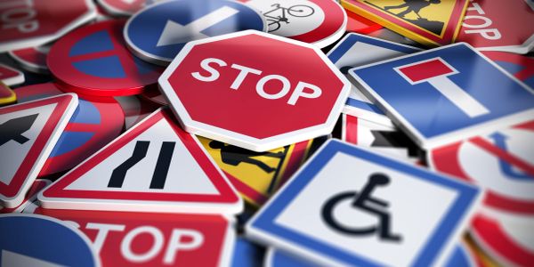 Pile of various traffic signs including stop and handicap.