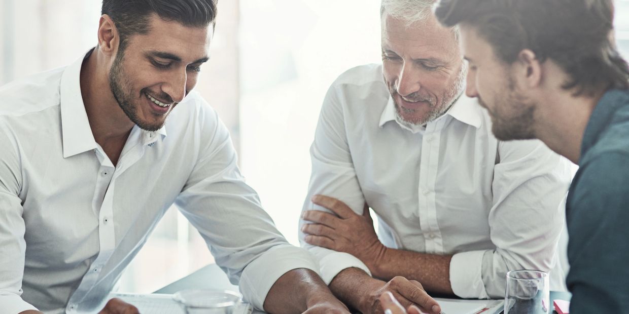 A group of three men smiling