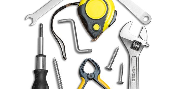 A collection of various hand tools including a wrench, screwdriver, tape measure, pliers, and screws.