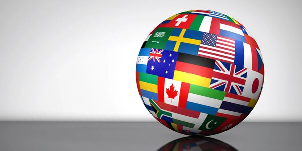 A globe composed of various national flags against a neutral background.