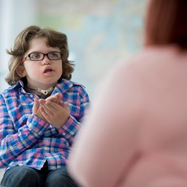 Child with a tracheostomy, signing with adult.