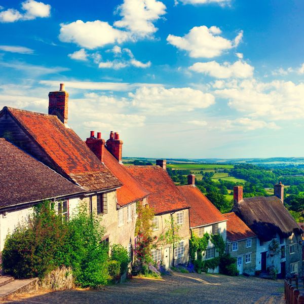 Charming countryside village with old houses and red roofs under a bright blue sky.