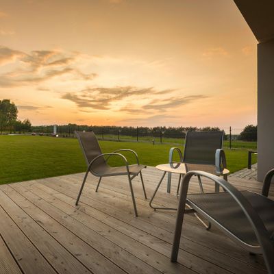 Outdoor patio with chairs and a beautiful sunset view.