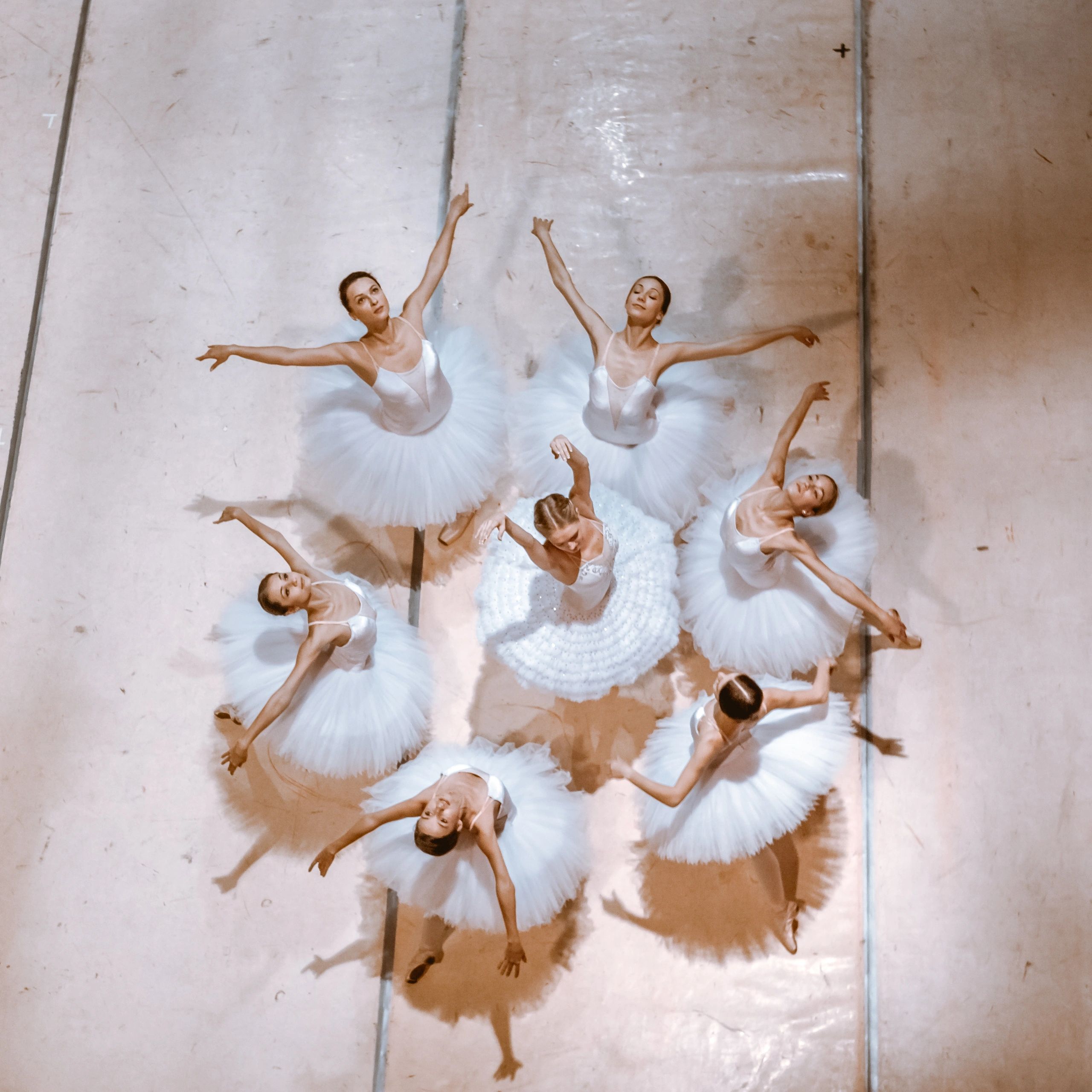 Ballet dancers in white tutus performing a graceful routine.