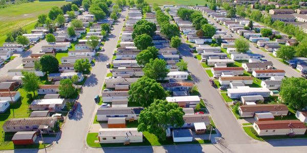 Aerial view of a mobile home park with green trees.