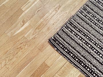 A patterned black and white rug on a wooden floor.