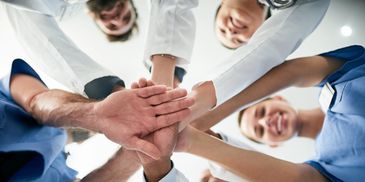 Healthcare team joining hands in unity.