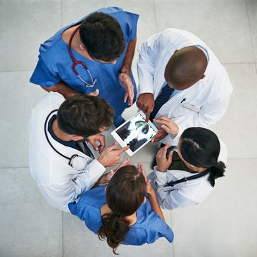 Doctors and nurses reviewing a patient's scan together.