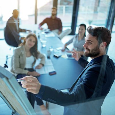 Businessman presenting ideas on a flip chart to colleagues in a meeting room.