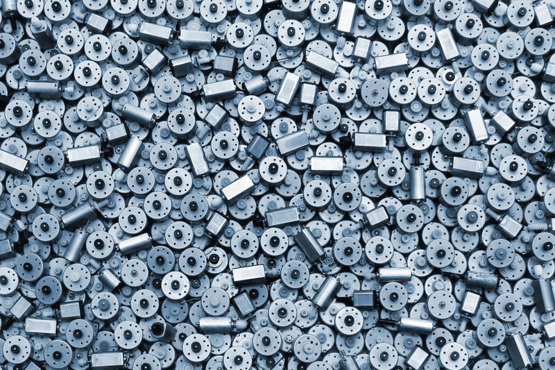 Many small used electric motors as background
