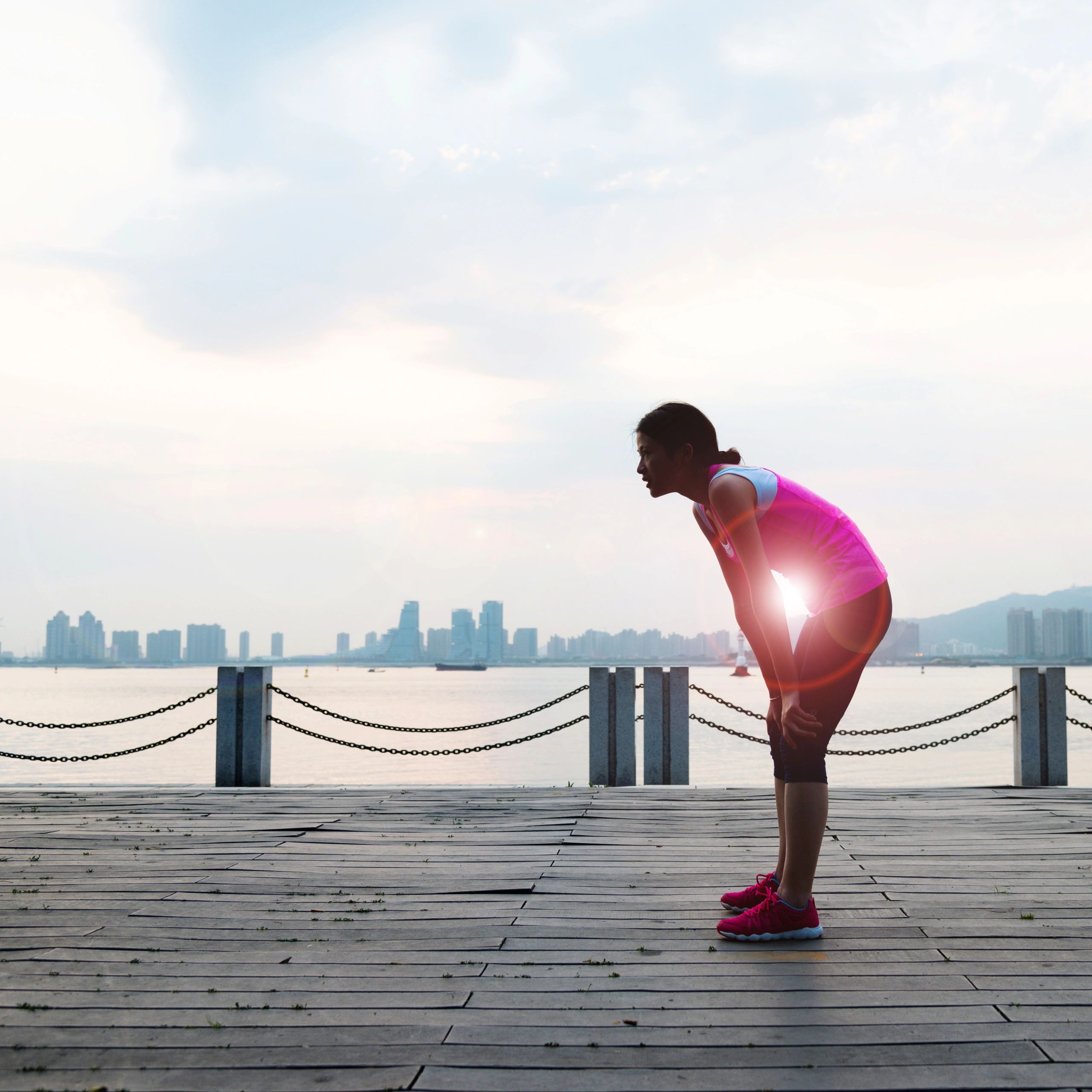 Woman resting after a run at waterfront.