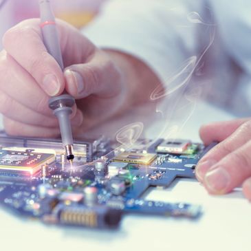 Hands soldering components on a computer circuit board.