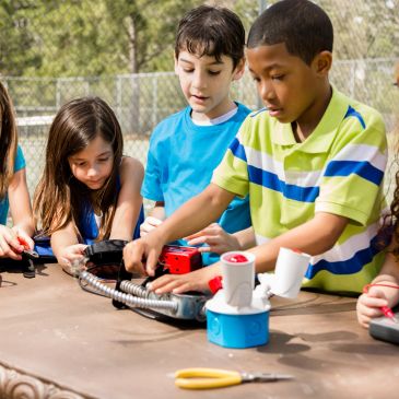 Children collaborating on a hands-on STEM project outdoors.