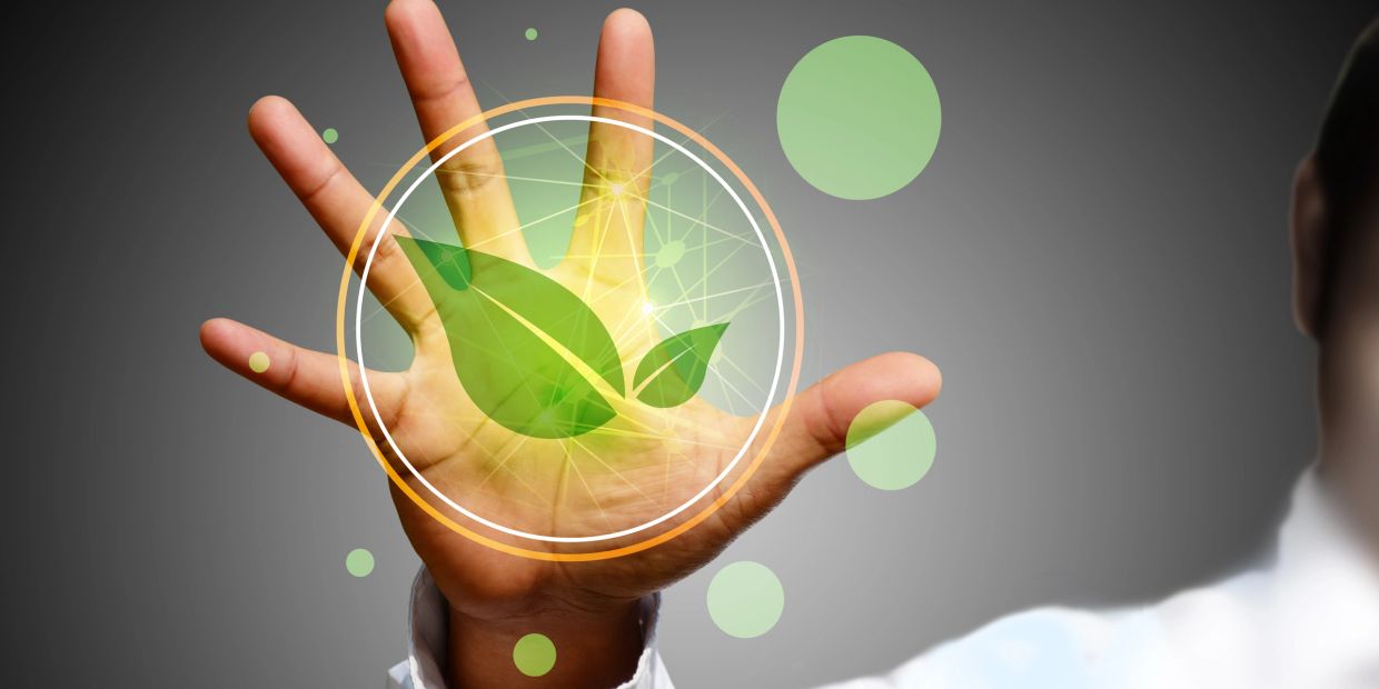 Hand with digital green leaf symbol representing eco technology.