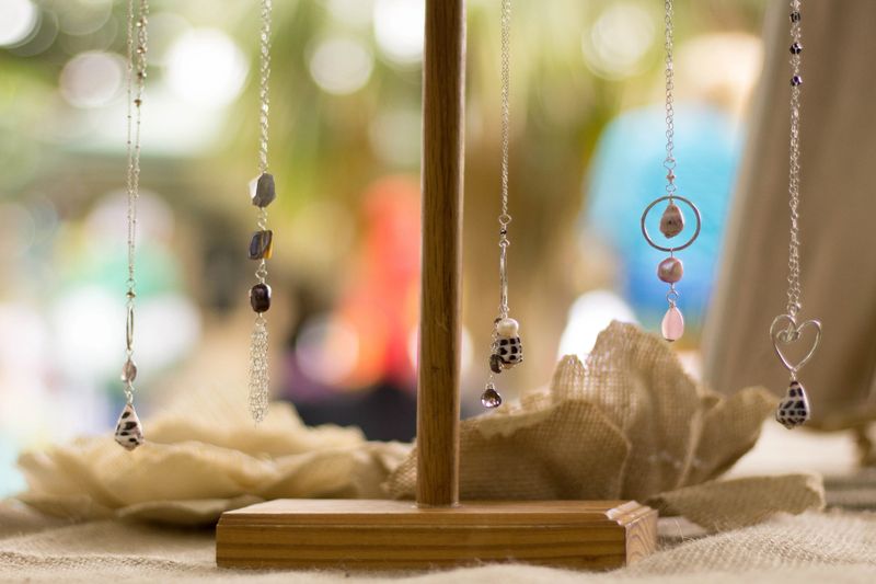 Handmade necklaces at a craft fair with bokeh of customers passing by.