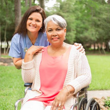 Personal support worker in Kingston, Ontario providing compassionate outdoor care and companionship to a senior in a wheelchair.