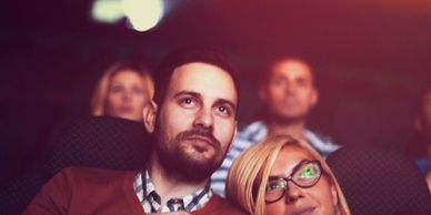 People attentively watching a movie in a theater.