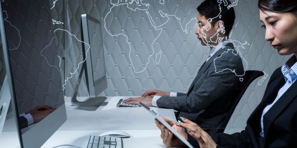 Person using a graphic tablet next to a computer screen with creative icons.