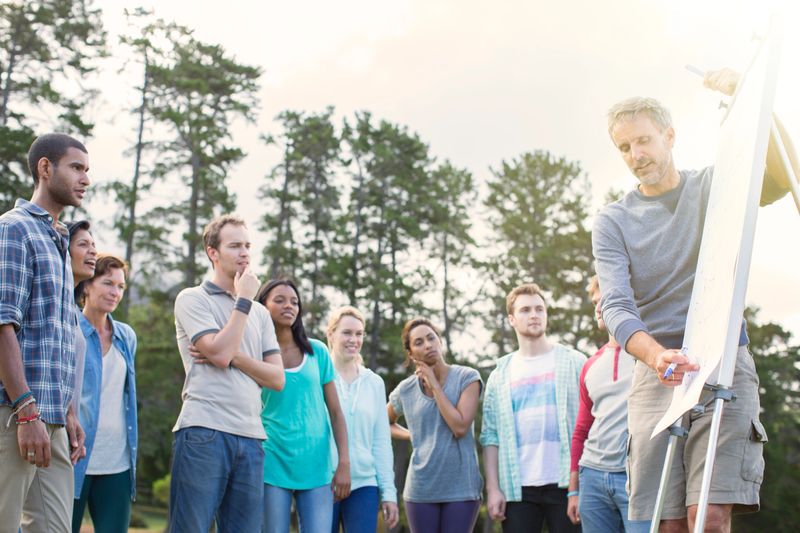 Man leading meeting at flipchart outdoors