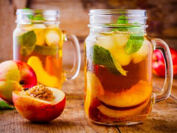 Iced peach tea with fresh mint in mason jars.