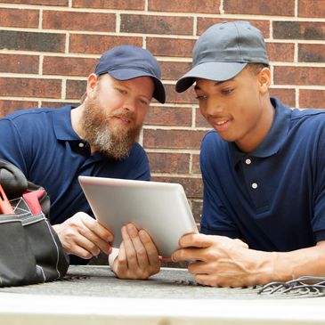 Two workers checking a tablet together.