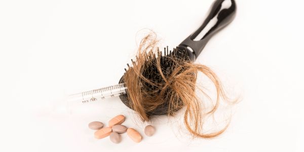 A hair brush with some pills and a comb