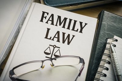 A book titled 'Family Law' with glasses resting on it.