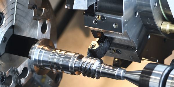A metal CNC lathe machining a cylindrical component.