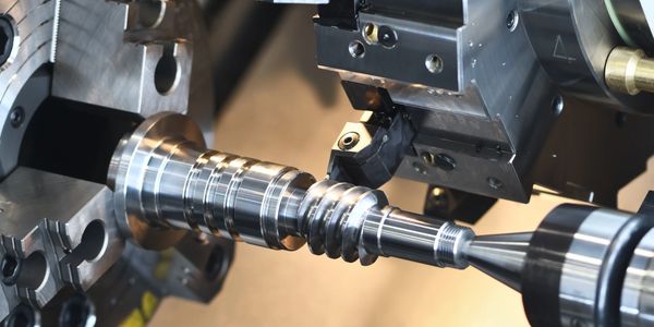 A metal CNC lathe machining a cylindrical component.