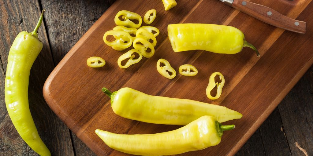 Yellow banana peppers on wooden cutting board