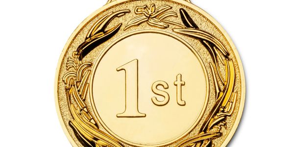 A shiny gold medal with '1st' engraved on it.