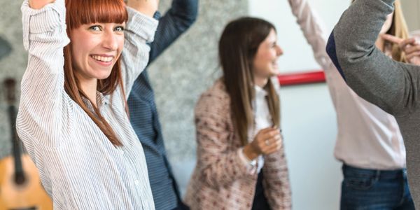 Happy group celebrating with raised hands indoors.