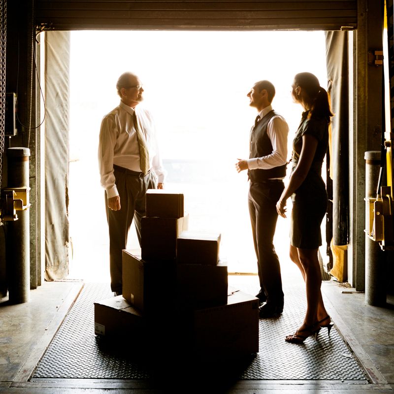 Hispanic man signing in packages in loading dock.