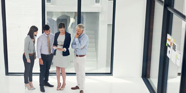 Group of four professionals standing and discussing.