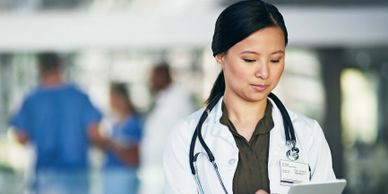 Female doctor using a tablet in a hospital setting.
