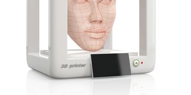 3D printer creating a detailed human face model with grid lines.