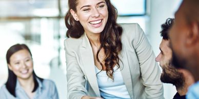 Businesswoman shaking hands with a colleague in a meeting.