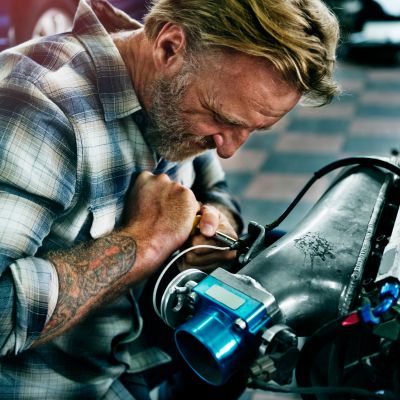 Man intensely working on a mechanical device.